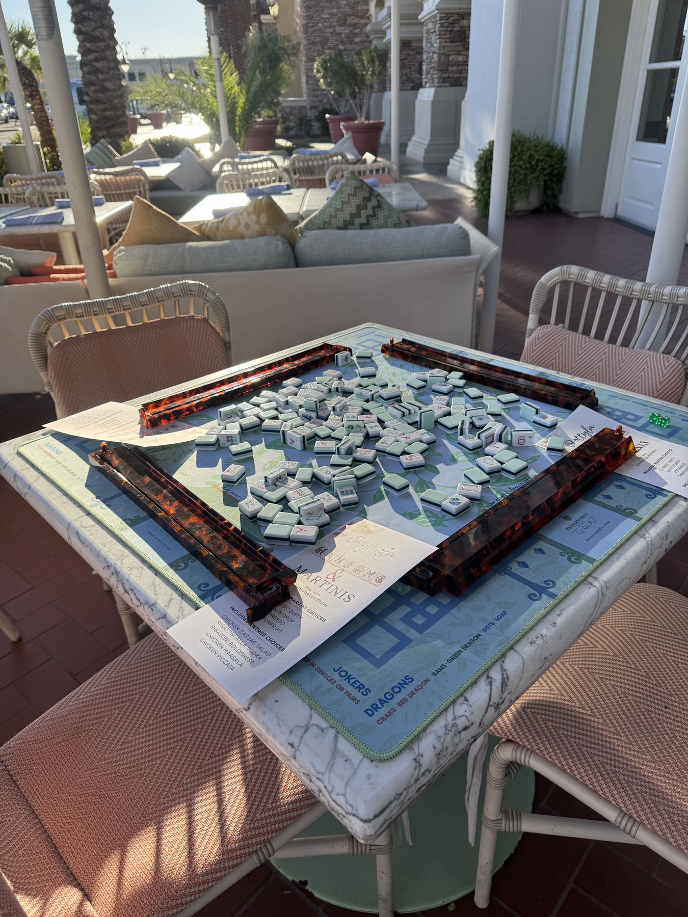 A mahjong table set on a sunny restaurant patio